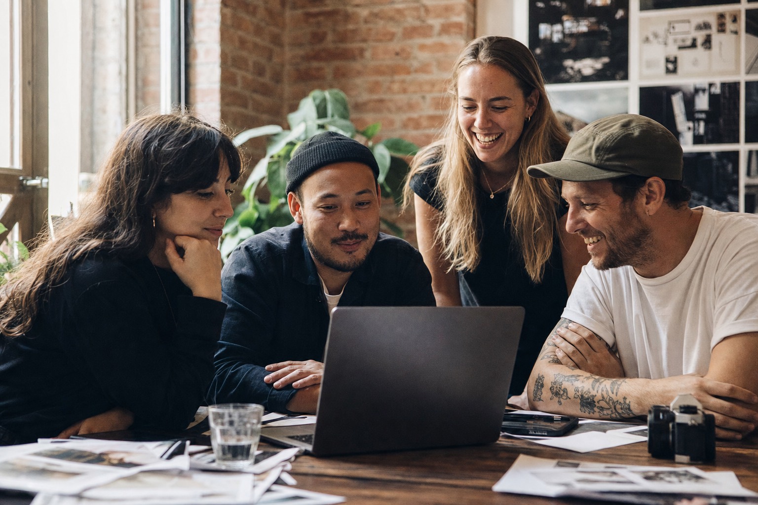 The Cryptopresale PR team gathered around a laptop reviewing a campaign in their studio